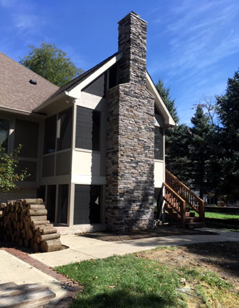 Screened porch addition with a stone chimney