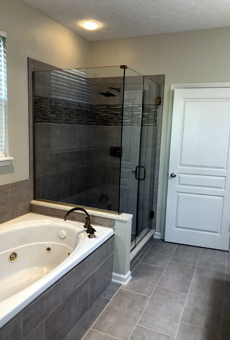 Master bathroom with a tiled walk-in shower and frameless glass enclosure